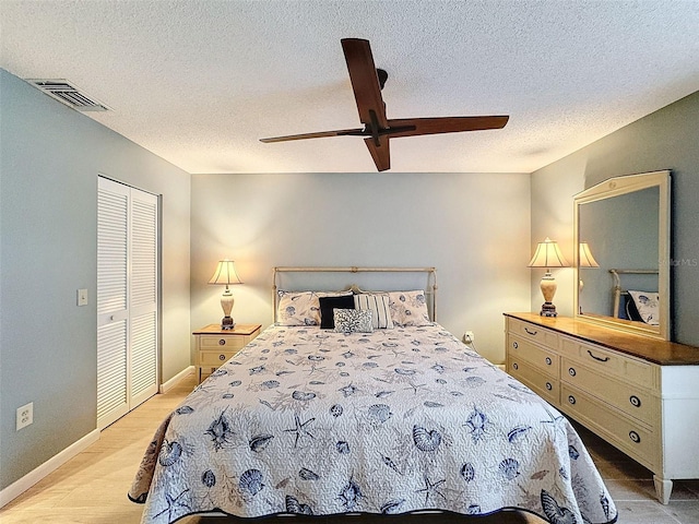 bedroom with ceiling fan, a closet, a textured ceiling, and light wood-type flooring