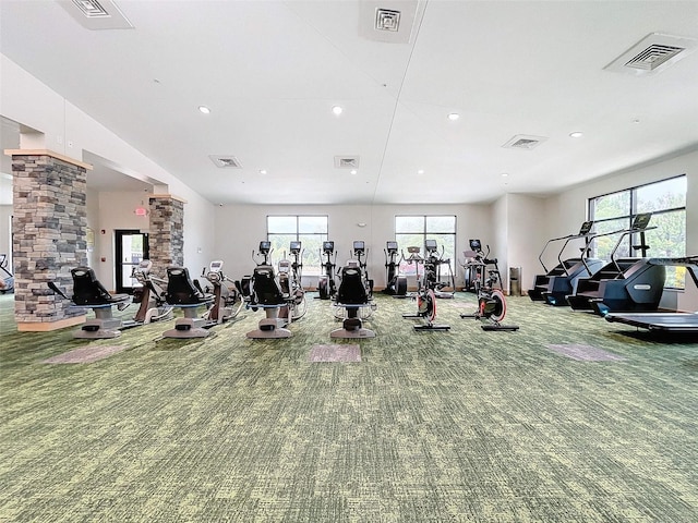 workout area featuring decorative columns and carpet flooring