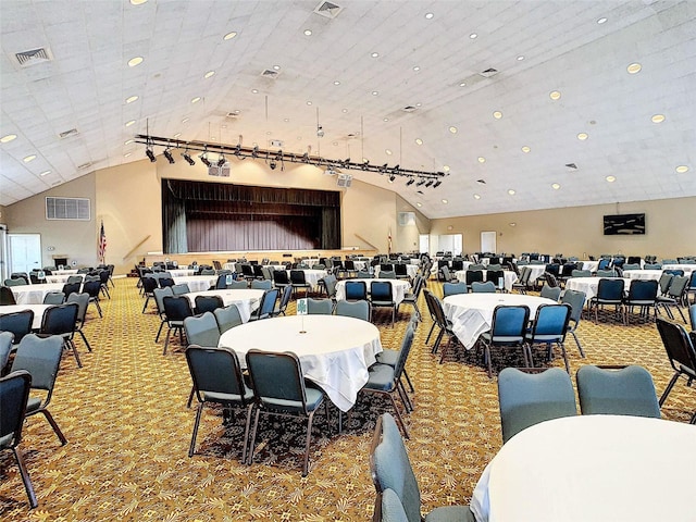 carpeted dining room featuring high vaulted ceiling