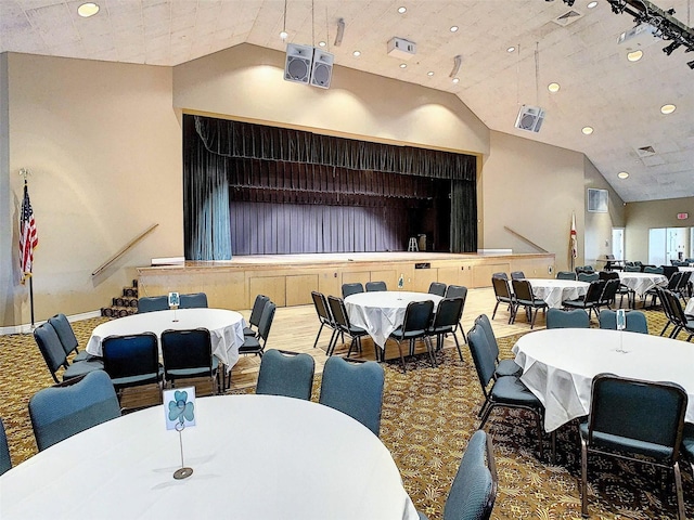 carpeted dining space with high vaulted ceiling