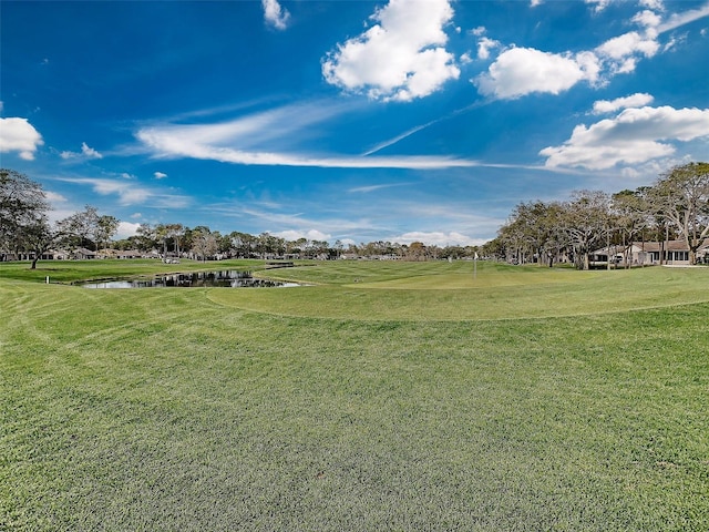 view of property's community with a lawn and a water view