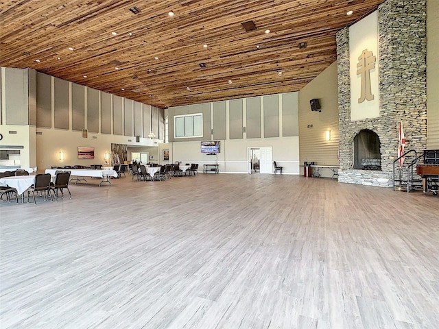 interior space featuring wood ceiling, a stone fireplace, and light hardwood / wood-style floors