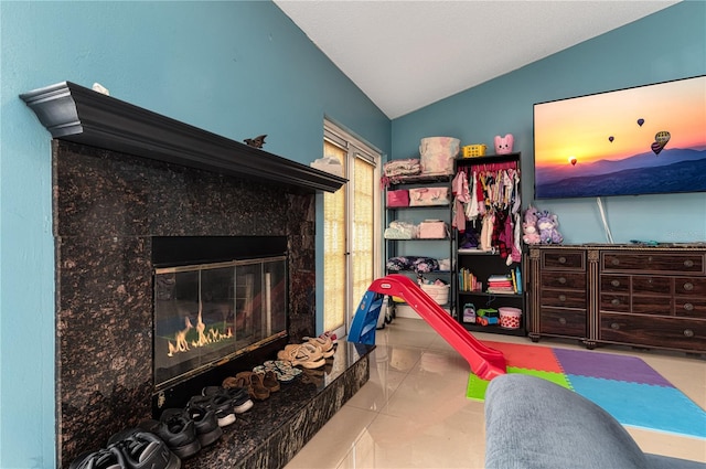 bedroom with lofted ceiling and a premium fireplace