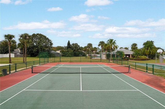 view of sport court with basketball hoop and a yard