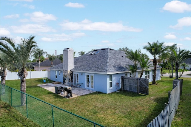 rear view of property with french doors, a patio area, and a lawn