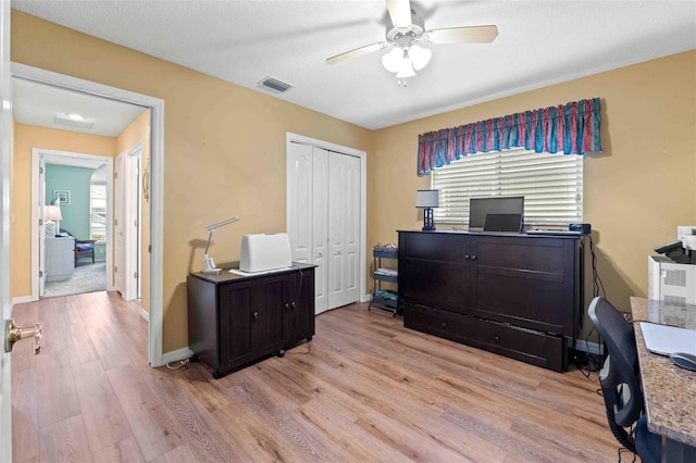 office space with ceiling fan, a healthy amount of sunlight, a textured ceiling, and light hardwood / wood-style flooring