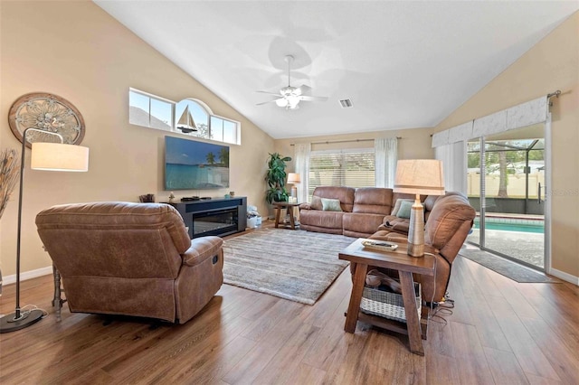 living room featuring hardwood / wood-style floors, high vaulted ceiling, plenty of natural light, and ceiling fan