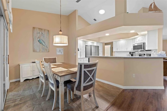 dining room featuring dark hardwood / wood-style flooring and high vaulted ceiling