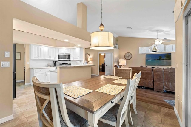 dining area with light hardwood / wood-style flooring, vaulted ceiling, and ceiling fan