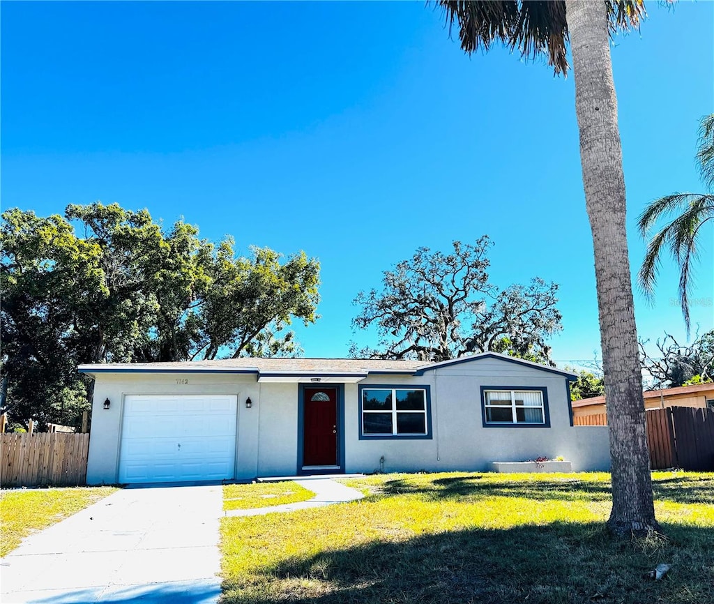 single story home featuring a front yard and a garage