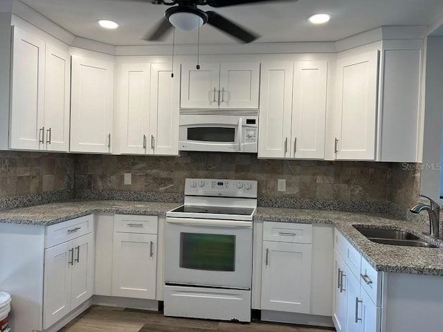 kitchen featuring sink, white appliances, backsplash, and white cabinets