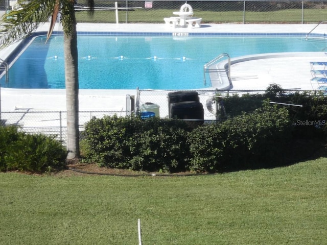 view of swimming pool featuring a yard