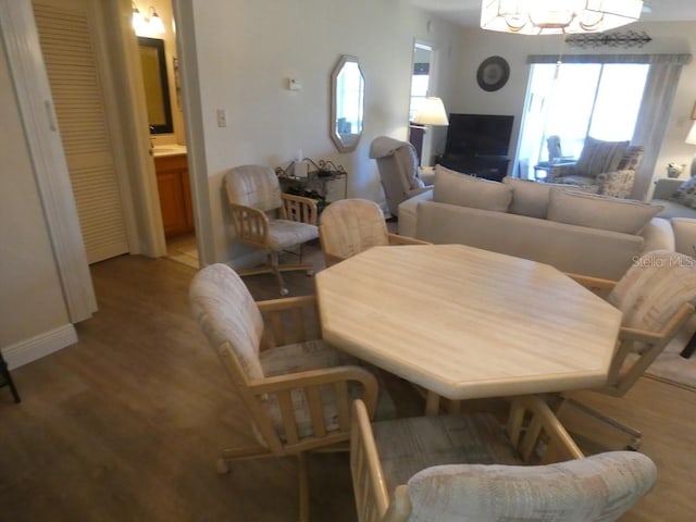 dining area with light wood-type flooring and a notable chandelier