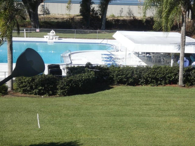 view of swimming pool with a yard