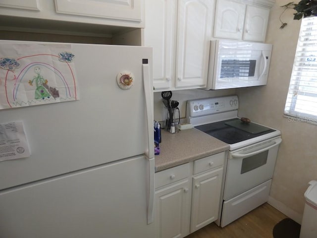 kitchen with white cabinetry, white appliances, and light wood-type flooring