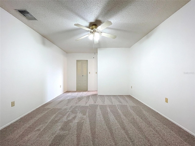 spare room with ceiling fan, light colored carpet, and a textured ceiling