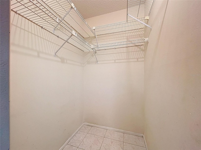 walk in closet with light tile patterned floors