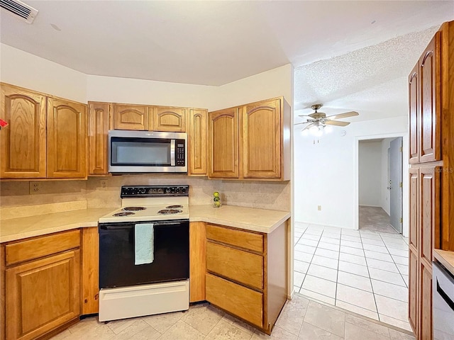 kitchen featuring backsplash, a textured ceiling, ceiling fan, electric stove, and light tile patterned flooring