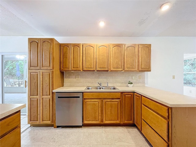 kitchen featuring sink, stainless steel dishwasher, a textured ceiling, tasteful backsplash, and kitchen peninsula