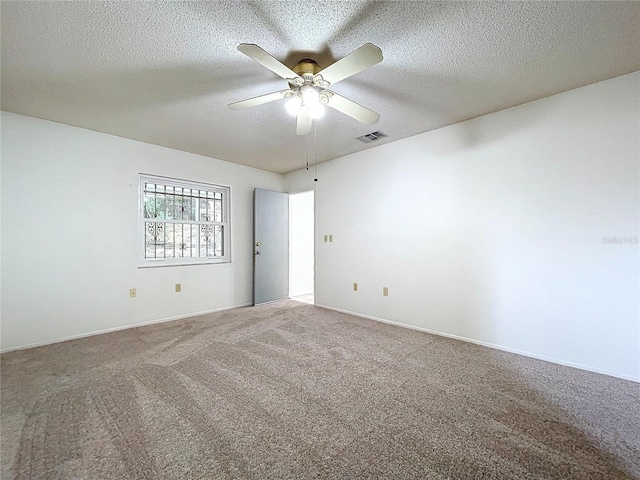 unfurnished room with ceiling fan, carpet floors, and a textured ceiling