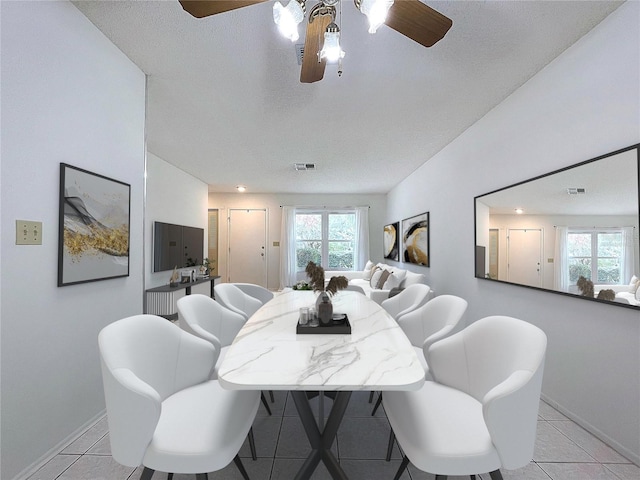 tiled dining room featuring ceiling fan and a textured ceiling