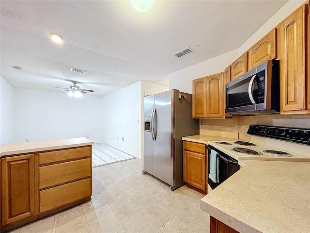 kitchen featuring ceiling fan, a textured ceiling, and appliances with stainless steel finishes