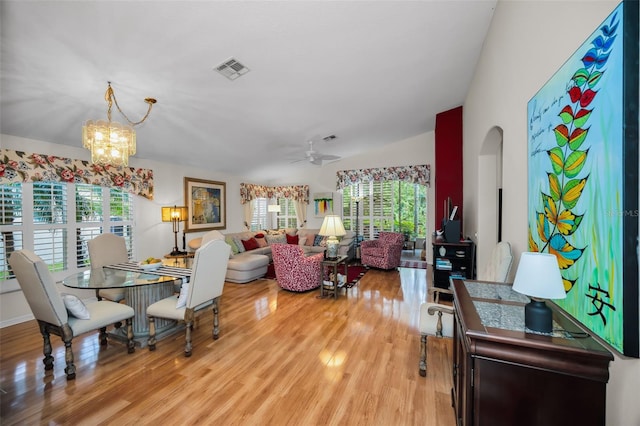 dining room with plenty of natural light, light hardwood / wood-style floors, and ceiling fan with notable chandelier