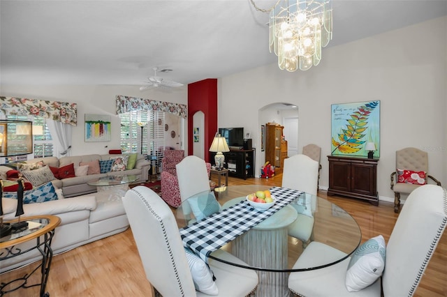 dining room with ceiling fan with notable chandelier and light hardwood / wood-style flooring