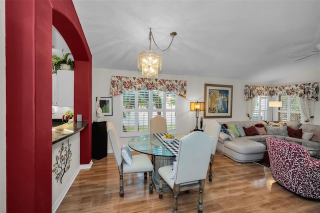 dining space featuring hardwood / wood-style flooring, an inviting chandelier, and a healthy amount of sunlight