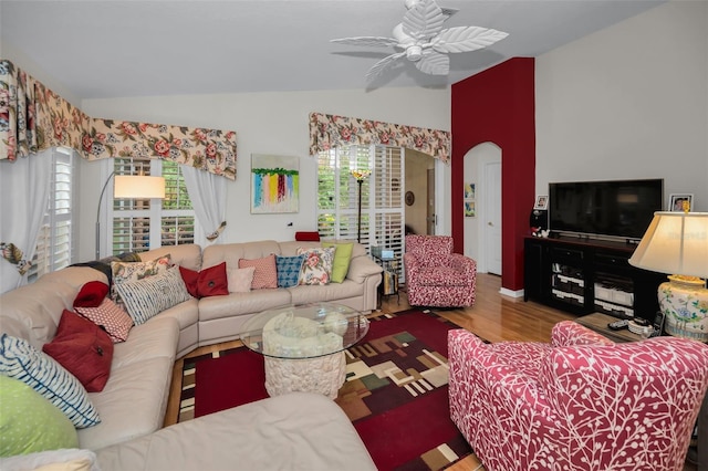 living room with ceiling fan, wood-type flooring, and vaulted ceiling