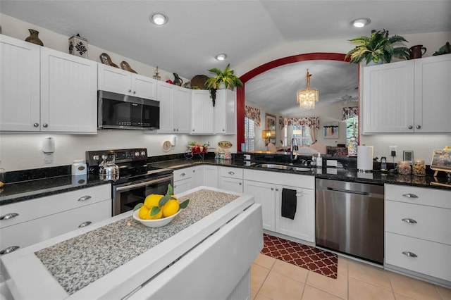 kitchen featuring white cabinets, hanging light fixtures, and appliances with stainless steel finishes