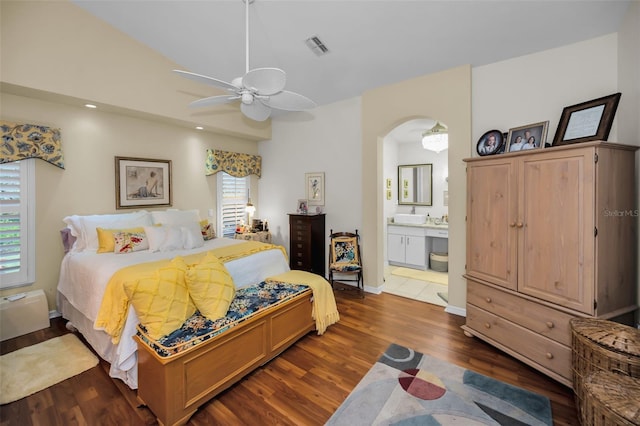 bedroom with connected bathroom, multiple windows, ceiling fan, and dark hardwood / wood-style floors