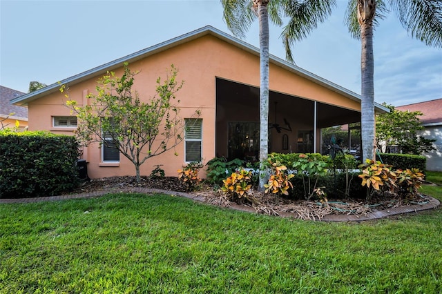 view of side of property featuring a lawn and a sunroom