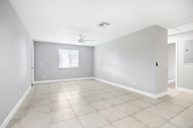 unfurnished room with light tile patterned floors, electric panel, and ceiling fan