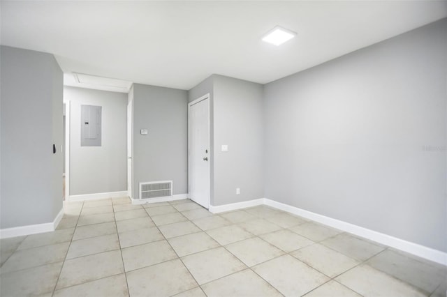 empty room featuring light tile patterned floors and electric panel