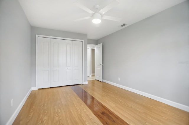 unfurnished bedroom with hardwood / wood-style floors, ceiling fan, and a closet