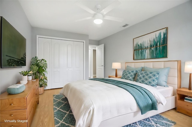 bedroom featuring light hardwood / wood-style floors, a closet, and ceiling fan