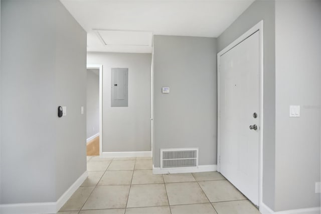 hall featuring light tile patterned floors and electric panel