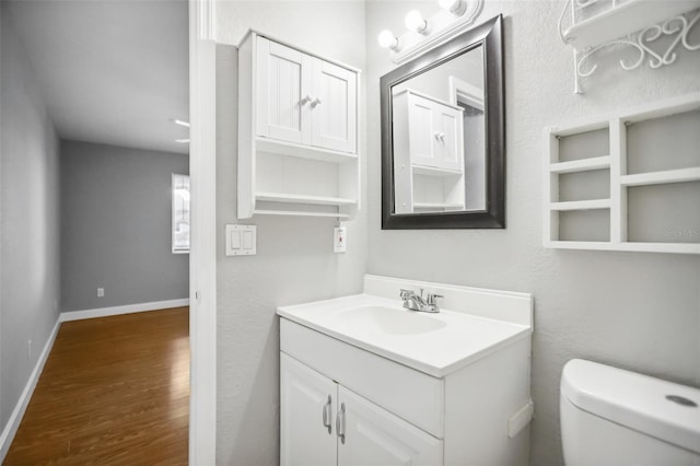 bathroom featuring hardwood / wood-style floors, vanity, and toilet