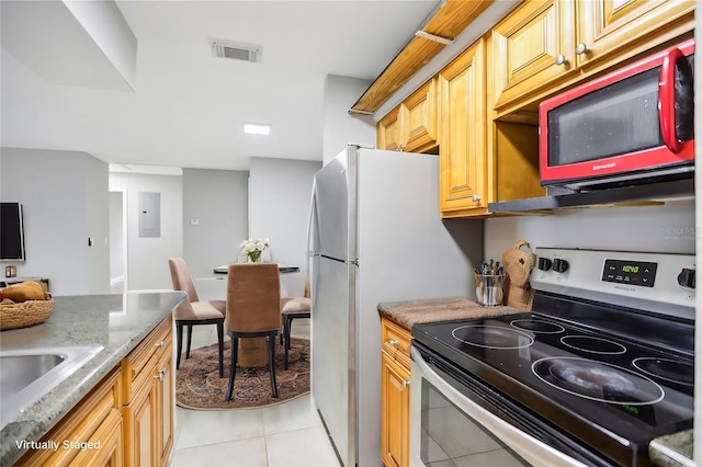 kitchen featuring sink, light stone counters, electric panel, light tile patterned flooring, and appliances with stainless steel finishes