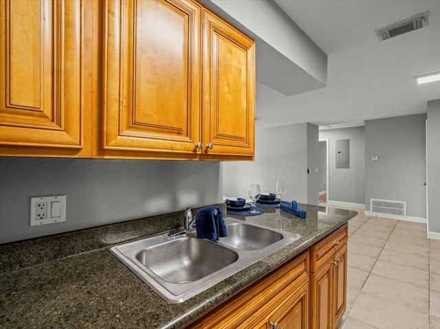 kitchen featuring visible vents, brown cabinets, and a sink