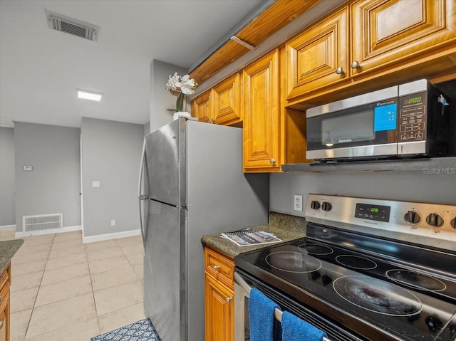 kitchen with visible vents, appliances with stainless steel finishes, brown cabinetry, and baseboards