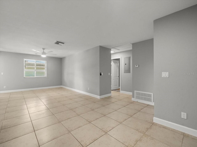 spare room with light tile patterned floors, visible vents, and electric panel