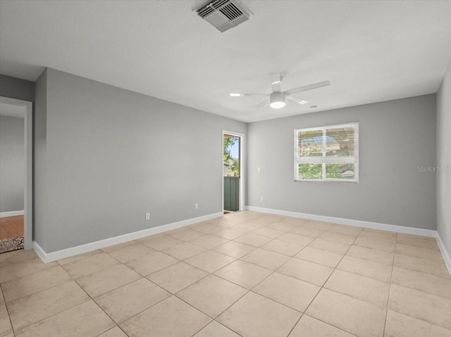 spare room featuring baseboards, visible vents, a ceiling fan, and light tile patterned flooring