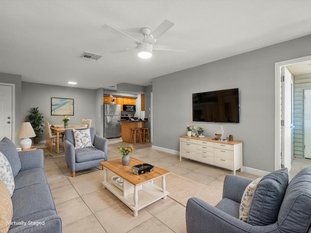 living area featuring light tile patterned floors, visible vents, ceiling fan, and baseboards