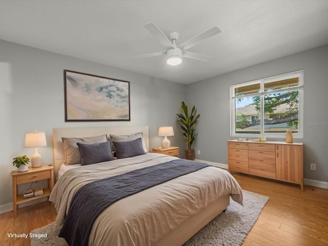 bedroom with baseboards, ceiling fan, and light wood finished floors