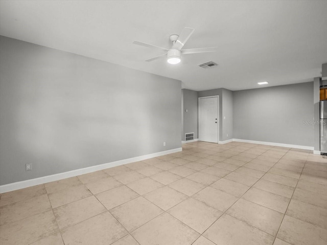 unfurnished room featuring baseboards, visible vents, light tile patterned floors, and a ceiling fan