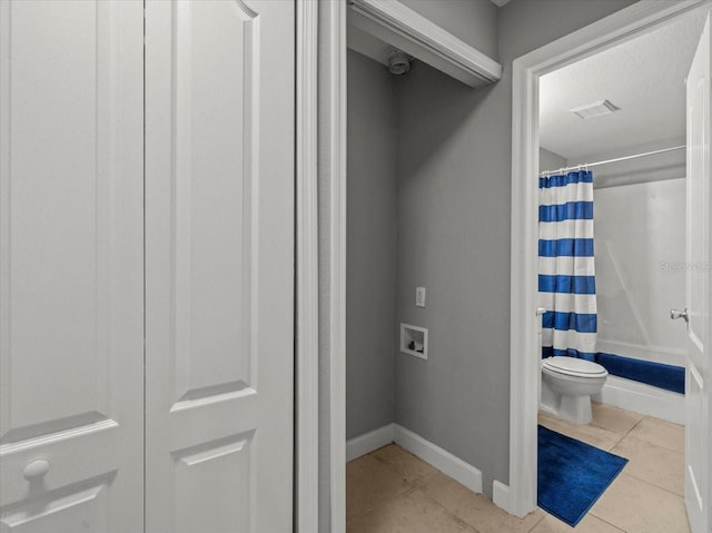 bathroom with visible vents, baseboards, toilet, shower / bath combination with curtain, and tile patterned flooring