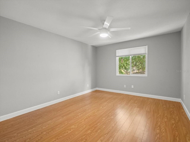 empty room featuring baseboards, ceiling fan, and light wood-style flooring