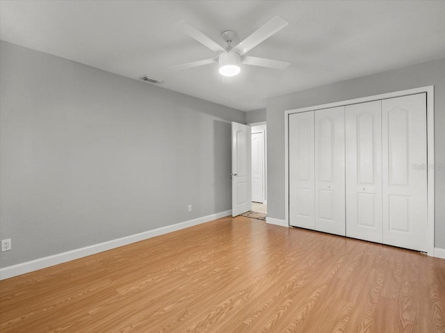 unfurnished bedroom featuring a closet, baseboards, and light wood-type flooring